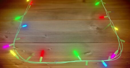 Animation of flickering fairy lights with copy space on wooden background
