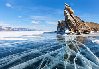 Sunny winter day on frozen Baikal Lake. View of the famous Cape Dragon on rocky northern tip of...