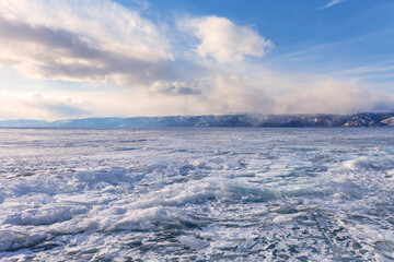 Frozen Baikal Lake. Ice hummocks and heaps of pieces of transparent ice on the Small Sea at sunset. Unusual winter landscape. Ice travel and outdoors