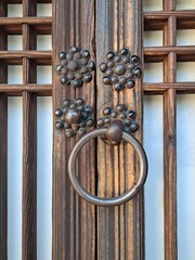 Naklejka premium Wooden plaid room doors with Hanji paper in the traditional Korean house - Old wooden doorknob decoration in the shape of plum flower 