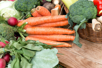 Fresh organic carrots and heap of other vegetables, healthy vegetarian food on table - 664410707