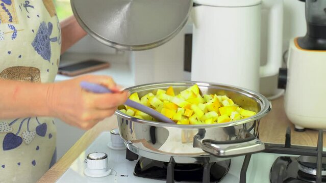 Stir diced zucchini in a frying pan. Cooking food.