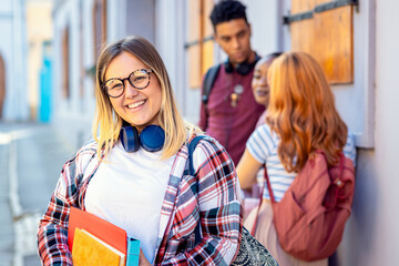 Portrait of smiling female student with friends looking at camera.