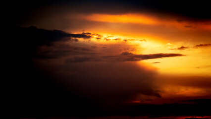 Fototapeta premium Picturesque view of orange sky with dark clouds in sunset time. Textured background of beautiful sunset. Beautiful background blur.