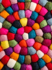 wool balls, with various hues intertwined to create a colorful and eye-catching pile.