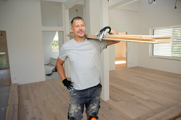middle-aged man with gray hair glued, laying parquet floor in my loft apartment, top floor