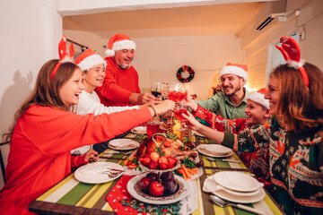 Group of happy family smiling happy celebrating christmas toasting with wine. Family member enjoy home made turkry grill dining togather at home. Christmas and New Year interior concept.