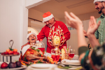 Group of happy family smiling happy celebrating christmas toasting with wine. Family member enjoy home made turkry grill dining togather at home. Christmas and New Year interior concept.