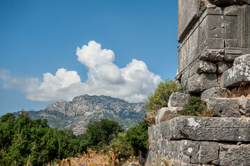 Fototapeta na wymiar Ancient old ruined tombs against cloudy sky in Turkey