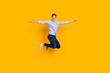 Full length body size view of attractive shopping guy jumping up show new clothes isolated yellow color background