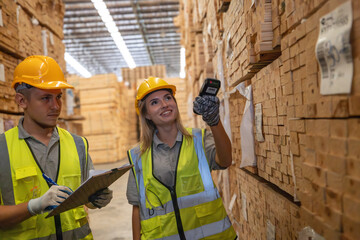 Warehouse staff verify wooded pallets items using handheld device, ensuring precise shipment. © SpaceOak