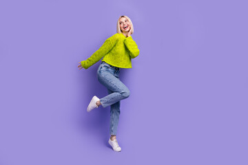 Full length photo of excited funky lady wear green pullover arm cheek looking empty space isolated purple color background