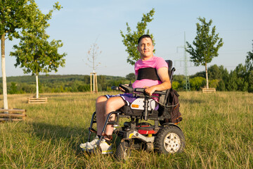 A man with disabilities in an electric wheelchair at the park.
