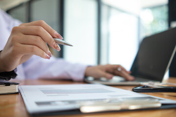 female doctor is reviewing documents to review and diagnose illness and female doctor has...