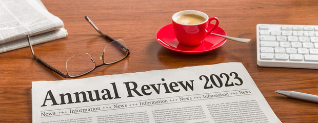 A newspaper on a wooden desk - Annual review 2023