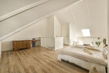 Fototapeta na wymiar a bedroom with wood flooring and white walls in an attic - style home that has been used for many years