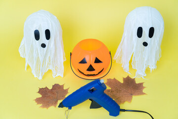 Obraz premium Halloween ghosts made from bandages, glue, water and using balloons and glasses on yellow orange background. Children's art project. DIY concept. Step by step 7. Halloween holiday concept.