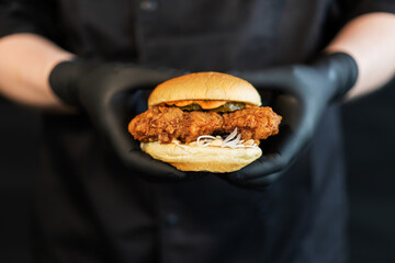 A craft juicy burger with cheese is held in the hands