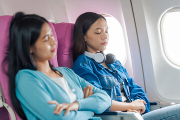 Female airplane passengers traveller asian chinese people airplane allies female friends, side by side. from booking tickets together, chronicling the intimate tales of friendship and wanderlust.