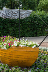 Kostroma, Russia, July 8, 2023. Stylized boat with flowers in the park.
