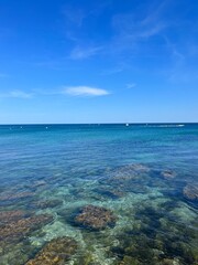 Transparent blue sea water, ocean bay, rocky coast, blue sky