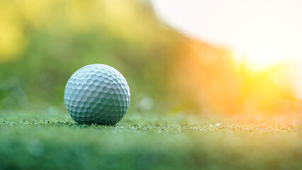 Golf ball on green lawn in a beautiful golf course with morning sunshine.