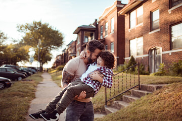 Loving young father embracing his son in the street