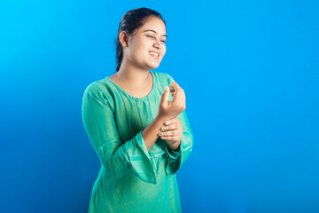 Portrait of an Indian women feeling pain in her injured wrist with painful grimace