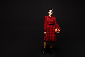 Full body young woman with Halloween makeup face art mask in clown costume red dress hold Jack-o-Lantern carved pumpkin isolated on plain black background studio portrait Scary holiday party concept