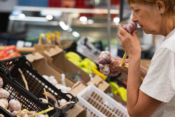 Portrait of senior caucasian woman buying fresh organic vegetables and fruit at market place and...