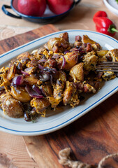 Fried potatoes with egg, chorizo sausage and red onions on a plate