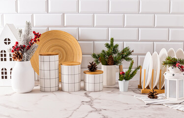 Beautiful stylish New Year kitchen background in traditional colors of New Year and Christmas. Stylish white tableware and jars for food storage.