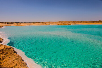 Obraz premium Salt lake with turquoise water and white salt on the shore near Siwa oasis, Egypt