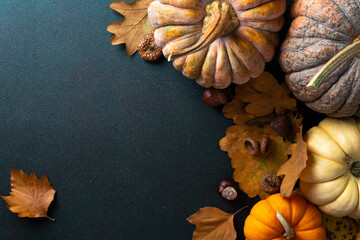 Thanksgiving greetings card. Autumn composition pumpkins, autumn leaves, acorns on dark background. Happy Thanksgiving, Halloween concept. Copy space