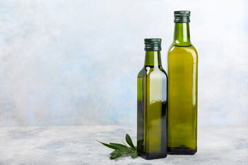 Olive oil in a bottle on texture background. Oil bottle with branches and fruits of olives. Place for text. copy space. cooking oil and salad dressing.