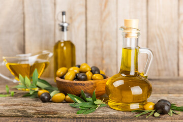 Olive oil in a bottle on texture background. Oil bottle with branches and fruits of olives. Place for text. copy space. cooking oil and salad dressing.