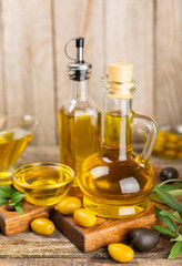 Olive oil in a bottle on texture background. Oil bottle with branches and fruits of olives. Place for text. copy space. cooking oil and salad dressing.
