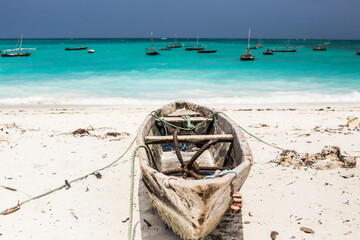 Beautiful Zanzibar coast line. Wooden fisherman boats on sandy beach with blue water background,...