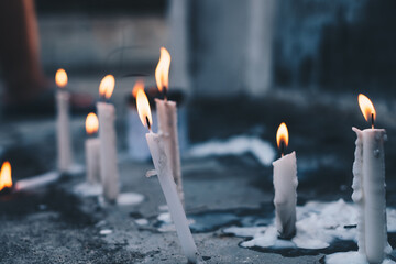 Several lighted candles in front of the tomb during a visit to a dead family member's  grave. Selective focus.
 - obrazy, fototapety, plakaty