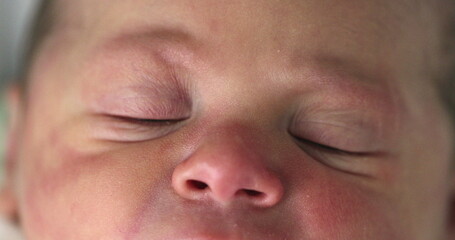 Close-up of newborn baby face in first day of life, macro closeup of infant eyes