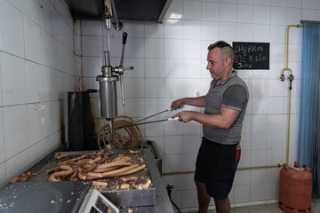 Cocinero friendo masa con dos palos de Churrero para hacer los churros. Los churros son un dulce frito tradicional español.