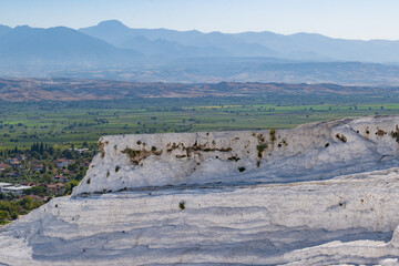 Green fertile agriculture land behind the chalk white geological heritage site of Pamukkale