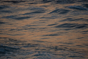 Dark melancholic water, concept of sadness in the ocean with sunset reflection on surface
