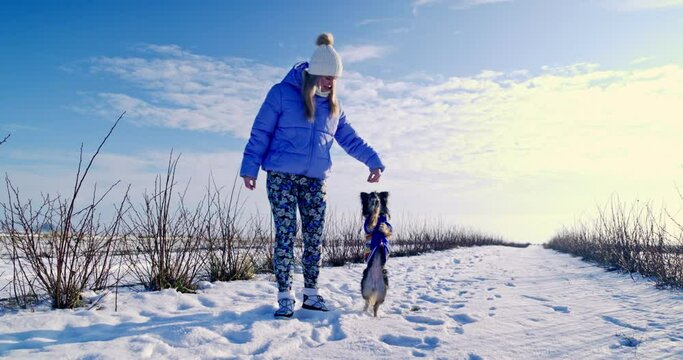 A young behaviorist is teaching her dog to perform new tricks on command.