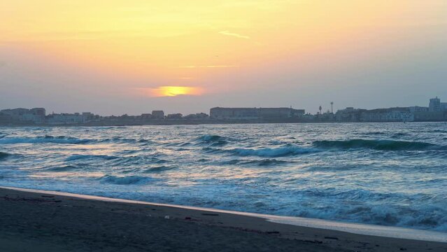 Homme qui court dans une plage en algerie avec couch&eacute; de soleil et vague