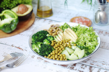 A bowl with a salad made of green vegetables