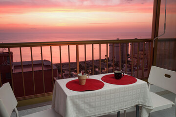 Café para dos en terraza con vistas al mediterraneo durante el amanecer de los Arenales del Sol, España