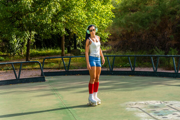 Middle aged woman in casual clothes rollerblading asphalt road in sunny day