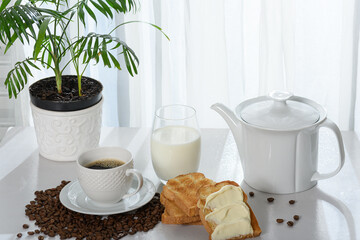 coffee table with toast, coffee cup with milk, coffee beans, cup with coffee, 