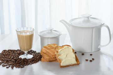 coffee table with toast, coffee cup with milk, coffee beans, cup with coffee, 